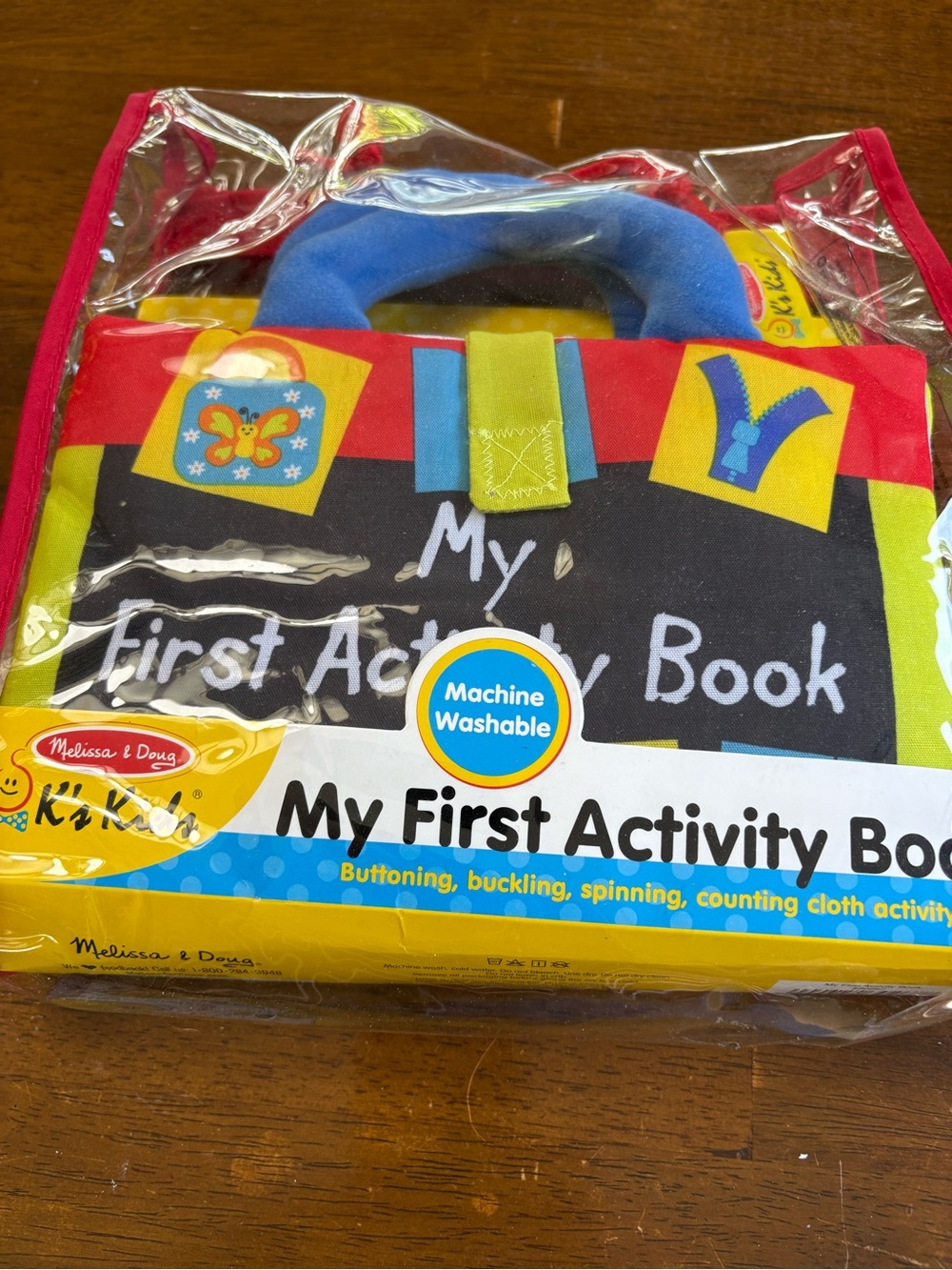 Melissa & Doug Soft Activity Book in Red, Blue, Yellow, Black